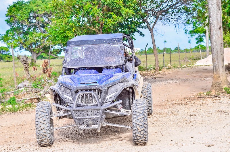 A blue buggy stopped on a dirt track in the Dominican countryside