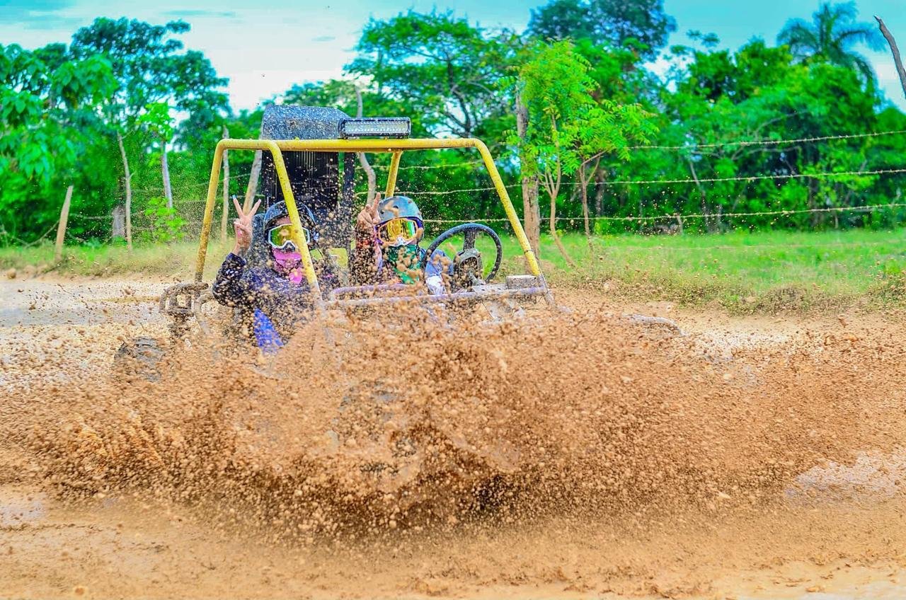A buggy throwing up a wall of mud out in the countryside