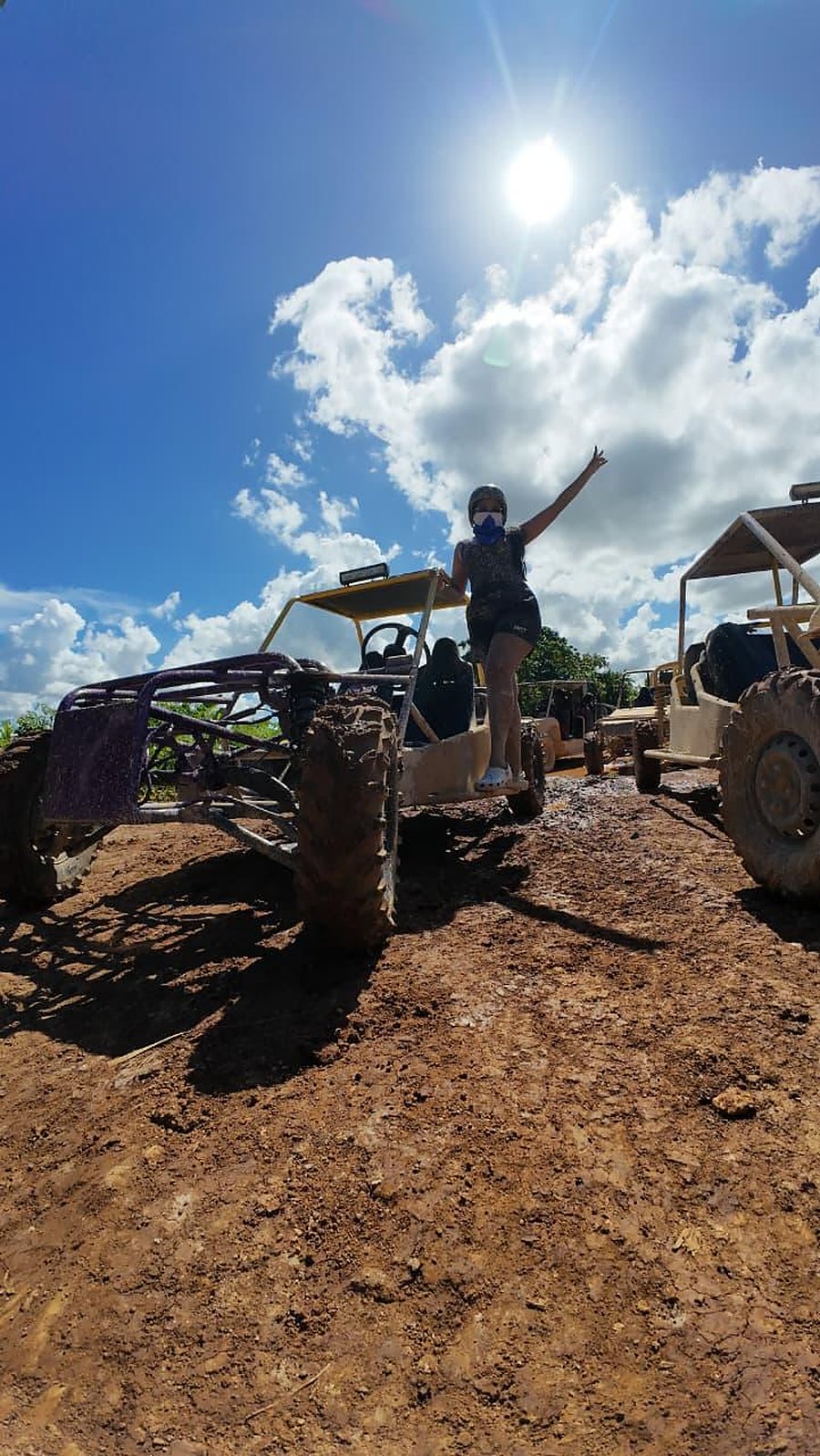 A traveller standing on her buggy, arms raised in the sun
