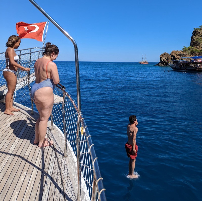 Swimmers jumping into the water from the deck