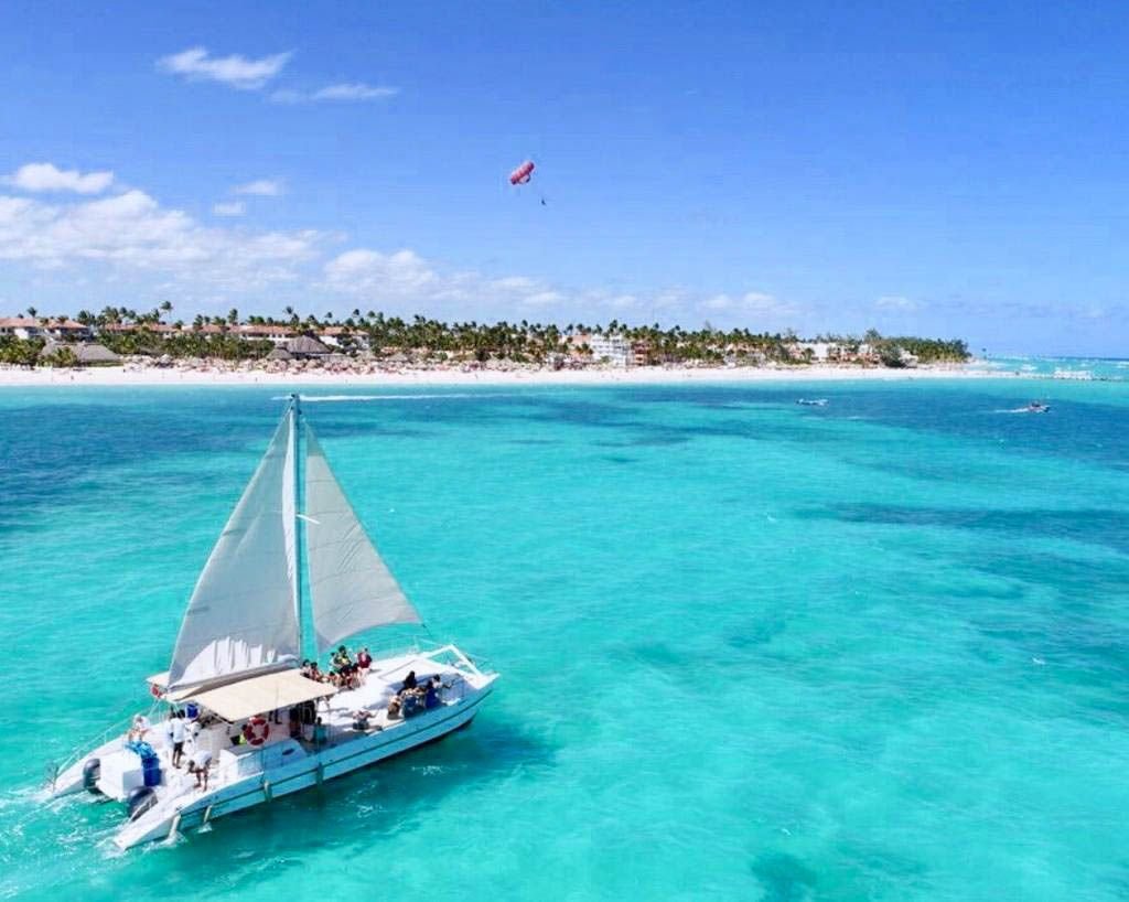 A sailing catamaran on turquoise water off the Bávaro coast