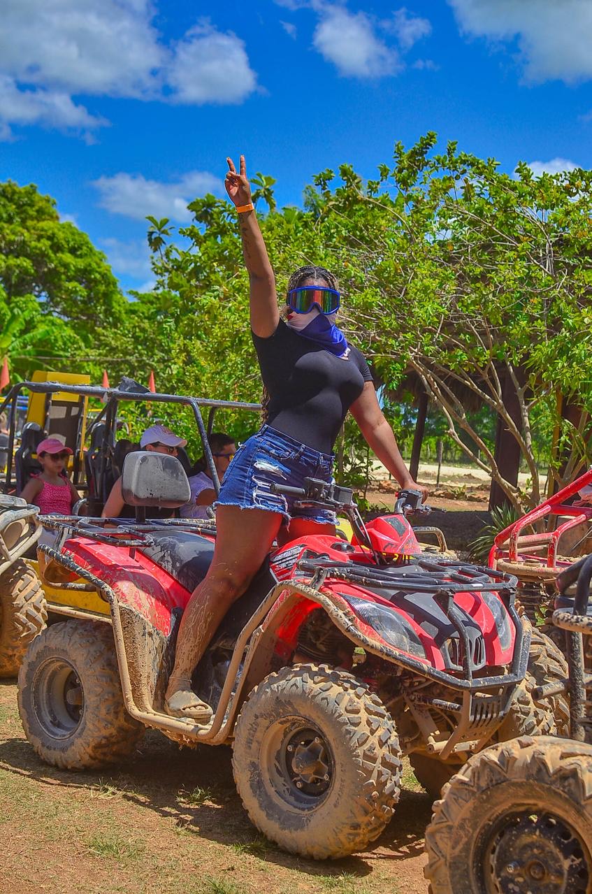 A traveller waves from her red quad bike before setting off