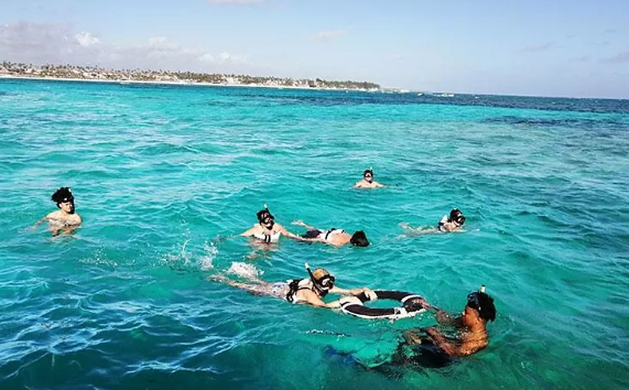 Travellers snorkelling in turquoise water