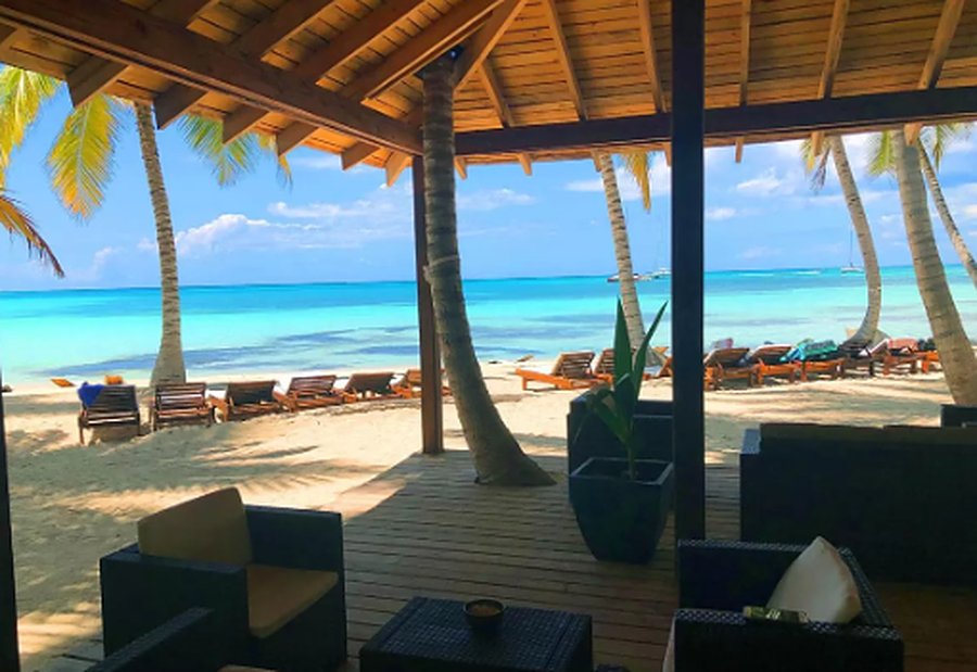 A deck with armchairs facing the turquoise sea