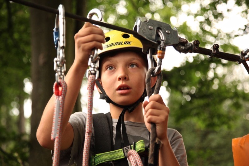 A boy in helmet and harness ready to ride