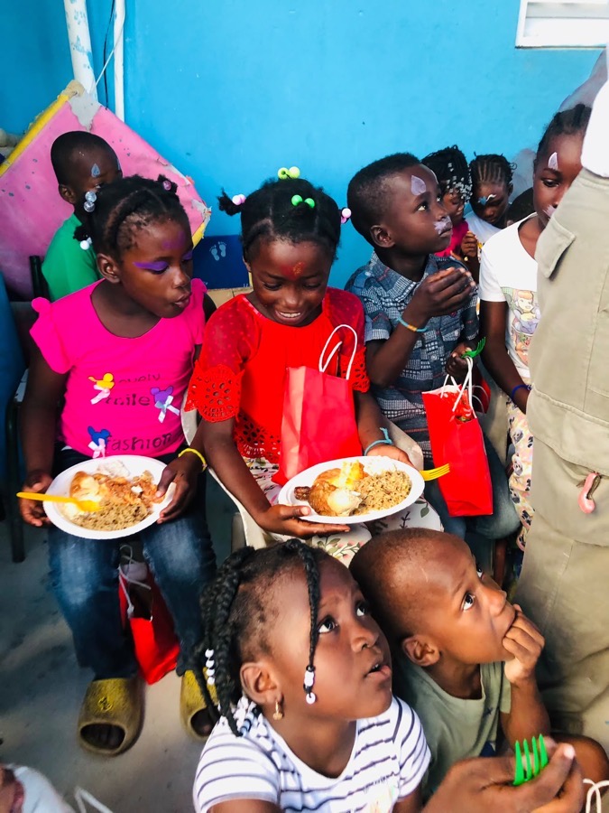 Two girls at the community kitchen holding their plate of food