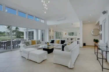 A double-height living room with white sofas