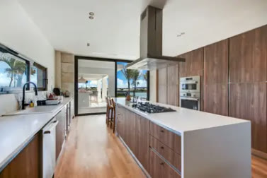A wooden kitchen with an island and white worktop