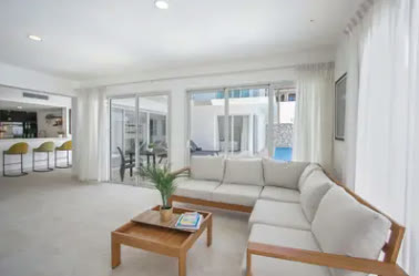 A white living room with sofas opening onto the terrace