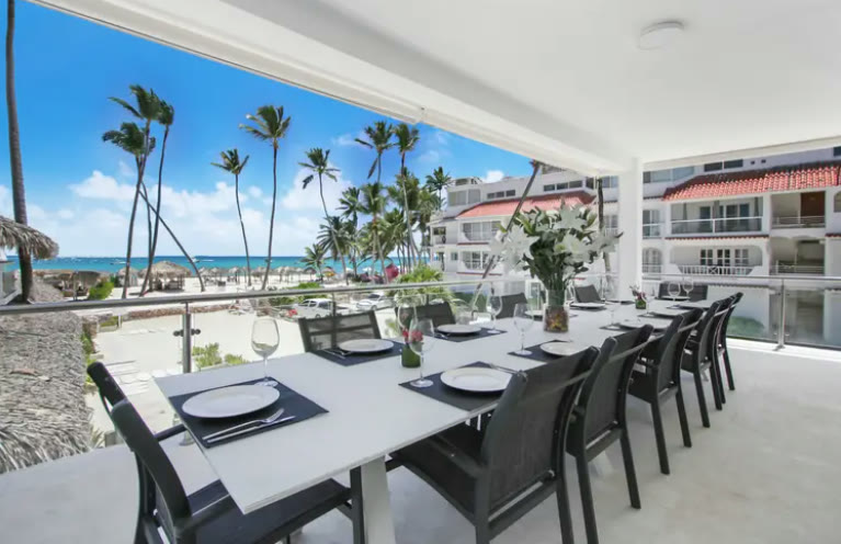 A twelve-seat dining table with an ocean view