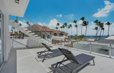 A terrace with sun loungers above the beach