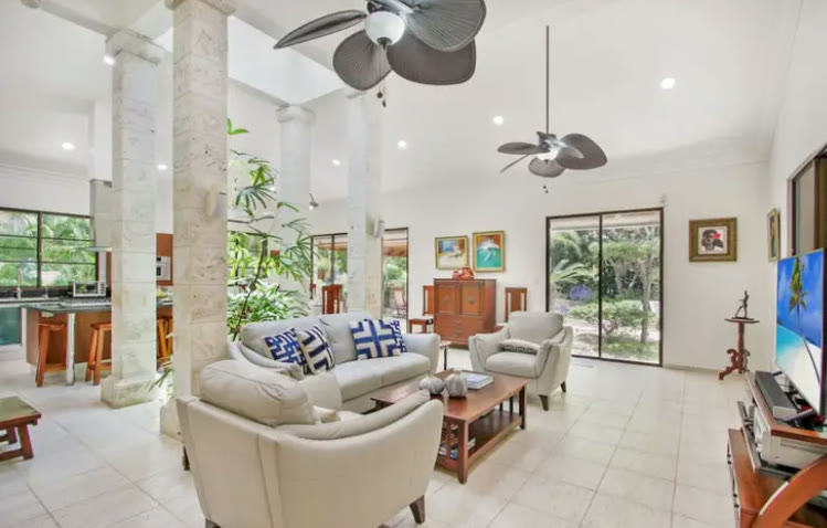 A living room with columns and white sofas