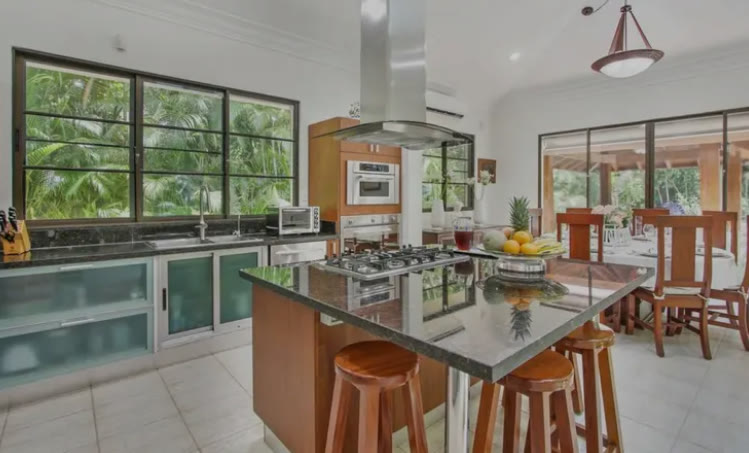 A kitchen with a granite island and stools